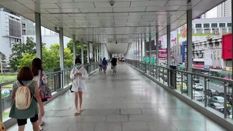 Menschen,-Die-Auf-Dem-Skywalk-Namens-„Skyline-Von-Bangkok“-Spazieren-Gehen,-Der-Das-Centralworld-Einkaufszentrum-Mit-Dem-Platinum-Fashion-Mall-Verbindet