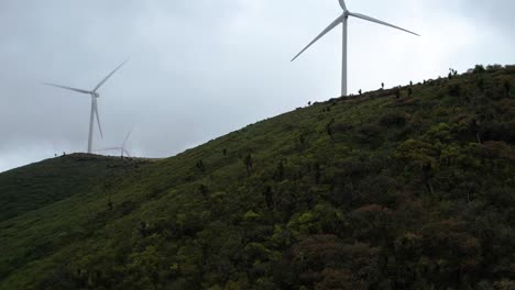 Luftaufnahmen-Von-Windmühlen-Oder-Aerogeneratoren,-Die-In-Den-Windigen-Bergen-Mexikos-Arbeiten