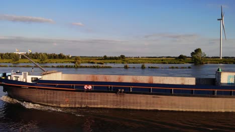 Aerial-Along-Port-Side-View-Of-FPS-Waal-Inland-Cargo-Vessel-Along-Oude-Maas-With-During-Golden-Hour