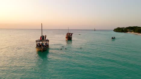 Nungwi-Beach,-Zanzibar---Tanzania---June-18,-2022---fishing-Boats-with-tourists-on-the-Indian-ocean-during-sunset