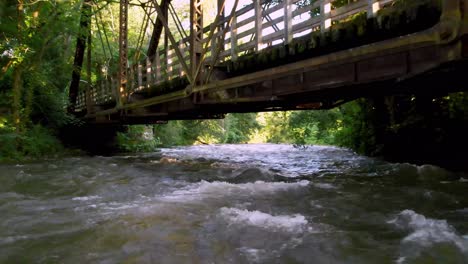 aerial-fast-pullout-river-in-damascus-virginia-under-iron-railroad-bridge