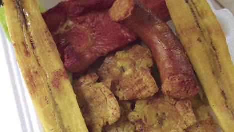 closeup-of-a-Peruvian-plate-of-patacones,-fried-ripe-plantain,-cecina-and-chorizo