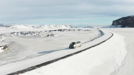 Una-Toma-De-Seguimiento-De-Un-Automóvil-Gris-Que-Viaja-En-Medio-De-La-Nieve