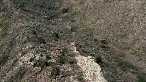 FPV-Downward-Tilting-Shot-of-Rocky-Wall-on-Mountain-in-Tenerife,-Spain