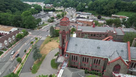 An-aerial-view-of-a-large-church-on-a-cloudy-day-in-a-suburban-neighborhood-on-Long-Island,-NY-with-green-trees