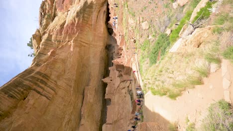 Tourists-walking-around-the-Long-House-cliff-dwelling-in-Mesa-Verde-National-Park,-vertical