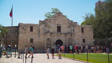 Die-Vorderseite-Des-Alamo-Gebäudes-Mit-Einer-Langen-Reihe-Von-Touristen,-Die-Aus-Der-Vorderseite-Herausragen