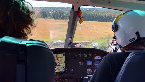 Two-Persons-in-Helicopter-Cockpit-during-Take-Off-in-Swedish-Countryside