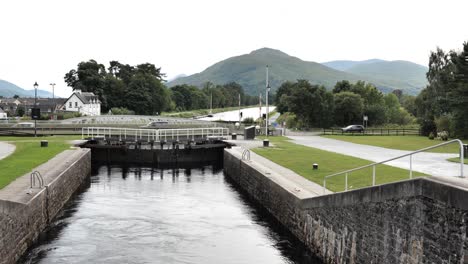 Gate-locks-of-Caledonian-Water-Canal-in-Fort-William,-Scotland-with-cars-driving-on-the-bridge