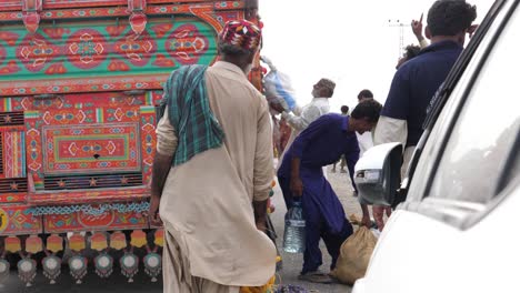 Sacos-De-Paquetes-De-Socorro-Por-Inundaciones-Que-Se-Bajan-De-Un-Camión-En-Baluchistán-A-Las-Personas-Que-Lo-Necesitan