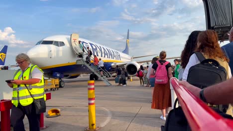 People-boarding-a-Ryanair-airplane-at-an-international-airport-in-Malaga-Spain,-people-going-on-a-holiday,-4K-shot