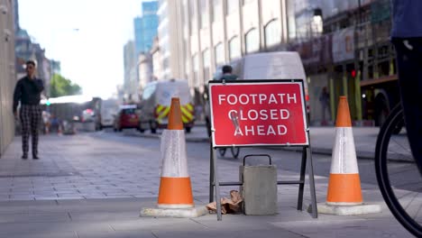 Farringdon,-London,-Vereinigtes-Königreich-–-August-2022-–-Auf-Dem-Bürgersteig-Ist-Zwischen-Zwei-Kegeln-Ein-Rotes-Schild-Mit-Der-Aufschrift-„Fußweg-Gesperrt“-Angebracht,-Um-Fußgänger-Zu-Warnen