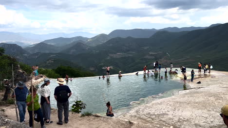 Hierve-El-Agua,-San-Lorenzo-Albarradas,-Oaxaca,-Mexiko,-Touristen-Besuchen-Erfrischende-Naturthermen,-Wasserbecken-Und-Felsschelf-Am-Rande-Des-Berges,-Mineralwasserquellen