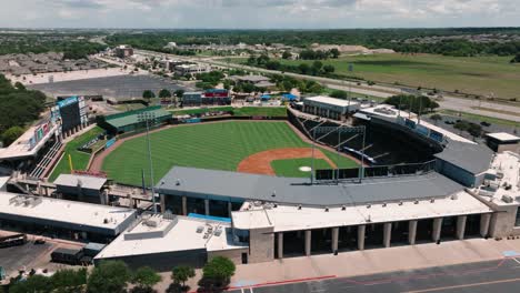 Round-Rock-Express-Dell-Diamond-Baseball-Stadium-aerial-drone-orbit-around-outfield-on-sunny-summer-Texas-day-with-4k-drone