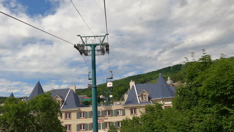 Aerial-Tramway,-Cable-Car-Ropeway-Cabin-View,-Rising-Up-Ascending-over-Mountain-Hotel-in-Mont-Tremblant-Region,-Tourist-Destination-in-Quebec-Canada,-Tourism-and-Leisure