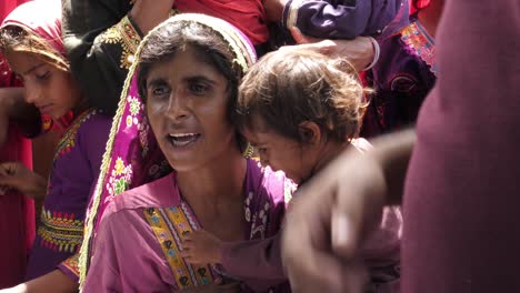 Madre-Con-Niño-Llorando-Hablando-En-El-Campamento-De-Ayuda-A-Las-Inundaciones-En-Sindh,-Pakistán