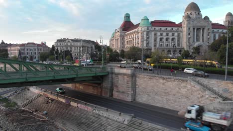 Slow-lifting-aerial-drone-footage-of-traffic,-Gellert-Square,-Budapest
