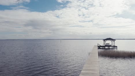 Late-afternoon-view-across-Lake-Waccamaw-with-pier-and-shimmering-reflections-of-clouds