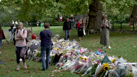 Floral-flower-bouquets-laid-in-tribute-and-mourning-after-the-death-of-Queen-II-Elizabeth-in-the-gardens-of-Green-Park,-London,-England