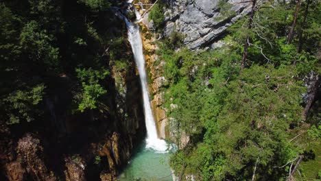 Stabile-Drohnenaufnahme-Eines-Riesigen-Wasserfalls,-Umgeben-Von-Felsigen-Bergen-Und-Wäldern
