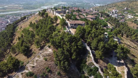 Drohnenaufnahme-Der-Albanischen-Unesco-Weltkulturerbestadt-Berat---Drohne-Fliegt-über-Eine-Burg-Den-Hügel-Hinauf