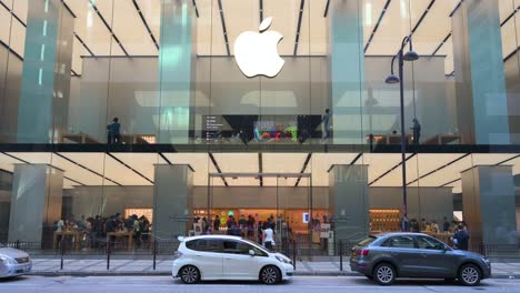 El-Tráfico-Pasa-Por-La-Vista-Frontal-De-La-Multinacional-Estadounidense-De-Tecnología-Apple-Store-Y-El-Logotipo-Se-Ven-En-Hong-Kong.