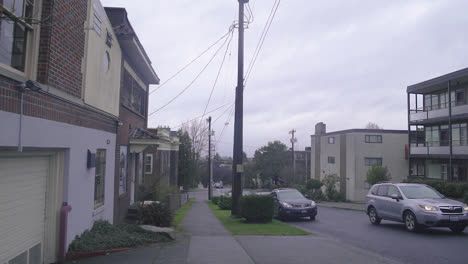 static-wide-shot-of-a-car-driving-through-a-residential-street-on-a-cold-overcast-day-in-Seatlle-Washington