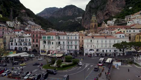 Tourists-in-the-center-of-Amalfi-city,-aerial-pedestal-down,-Amalfi-coast