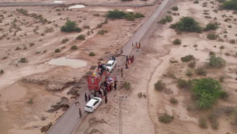 Drone-capture-the-aerial-shot-of-a-truck,-where-people-are-delivering-food-to-Pakistani-flood-victims-as-a-kind-of-relief