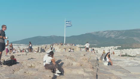 Touristen-Sitzen-Um-Griechische-Flagge-über-Der-Akropolis