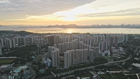 Sonnenuntergang-über-Dem-Anwesen-Tin-Shui-Wai,-Im-Hintergrund-Die-Shenzhen-Bay-Bridge