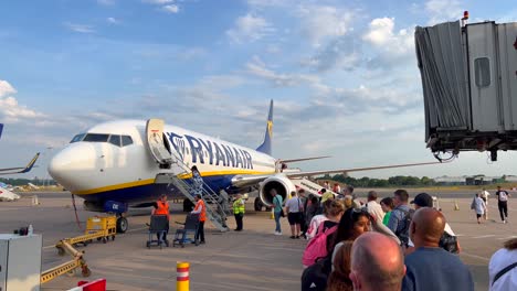 People-boarding-a-Ryanair-airplane-at-an-international-airport-in-Malaga-Spain,-Ryanair-airplanes,-people-going-on-a-holiday,-4K-shot