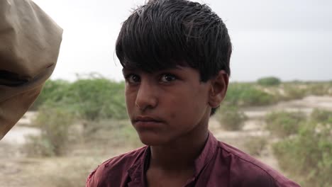 Niño-Varón-Joven-Que-Parece-Abatido-Durante-El-Alivio-De-Las-Inundaciones-En-Baluchistán