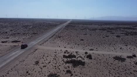 The-drone-image-shows-a-car-on-a-deserted-road-on-its-way-to-a-wind-farm