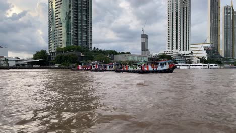 Tugboats-pulling-a-barge-at-Chao-Phraya-river-in-Bangkok,-Thailand