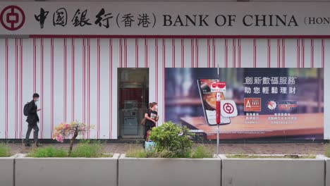 Chinese-pedestrians-and-commuters-walk-past-the-Hong-Kong-based-banking-and-financial-services-company-and-primary-indicator-of-the-Hong-Kong-stock-market,-Hang-Seng-Bank,-branch-in-Hong-Kong