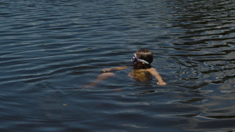 Kid-with-goggles-on-head-bathing-in-a-lake
