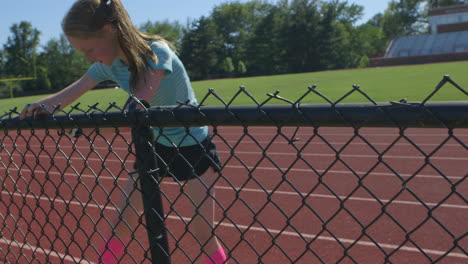Young-athletic-teenager-warms-up-at-the-high-school-track-before-a-run