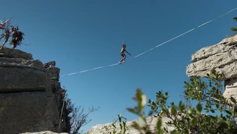 gimbal-shot-of-men-on-a-slackline-on-top-of-a-mountain-in-slow-motion