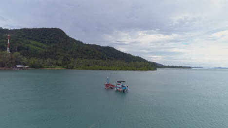 Schwenkaufnahme-Eines-Sinkenden-Fischerbootes-Vor-Der-Küste-Einer-Idyllischen,-Einsamen-Insel-In-Thailand