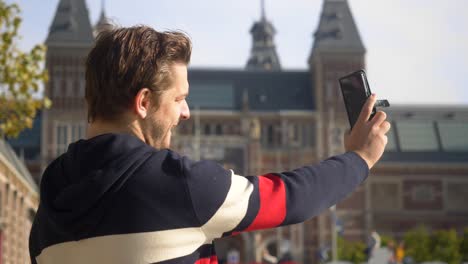 Hübscher-Junger-Mann,-Der-Ein-Selfie-Vor-Dem-„I-Amsterdam“-Schild-In-Amsterdam-Macht