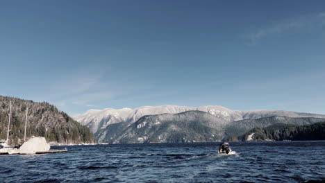Boat-leaving-deep-cove-dock-towards-mountains
