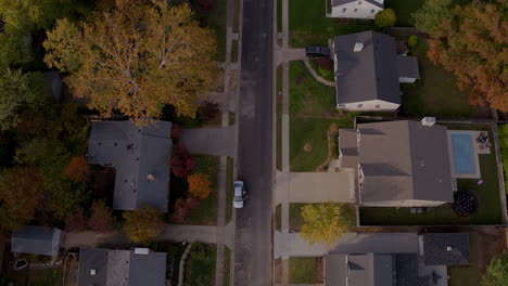 Overhead-flyover-of-a-suburban-street-and-houses-in-Autumn