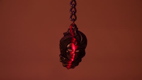 Close-Up-of-the-Metal-Venetian-Mask-Souvenir-Keychain-and-the-Vertical-Laser-Light