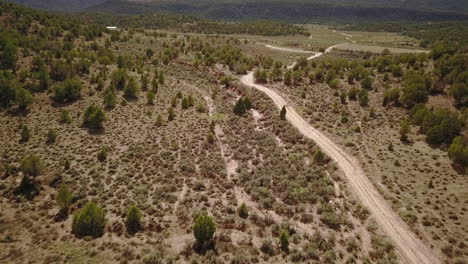 Antena-De-Camino-De-Tierra-Con-Butte-Mesa-Flat-Top-Mountain-En-Un-Hermoso-Día-En-El-Desierto-Suroeste-De-Colorado,-EE.UU.