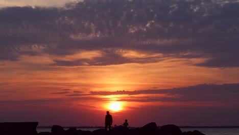 Ein-Vater-Und-Sein-Sohn-Gehen-Bei-Sonnenuntergang-Die-Küste-Entlang
