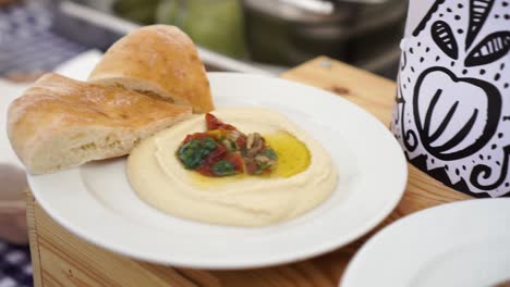 SLOWMO---Plate-of-hummus-on-white-plate-at-food-festival---Close-Up