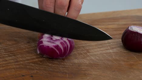 Slicing-a-red-onion-on-a-cutting-board-in-preparation-to-stir-fry