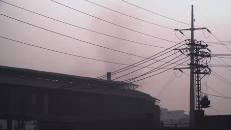 Die-Industrielle-Umweltverschmutzung-Wirkt-Sich-Auf-Die-Bevölkerung,-Elektrische-Umfragen-Und-Kabel-An-Der-Straße-Zum-Fabrikgebäude-Aus