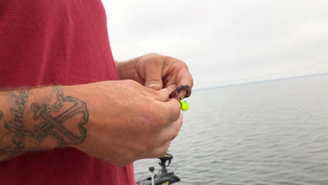 Man-preparing-bait-on-fishing-hook-to-go-fish-on-boat